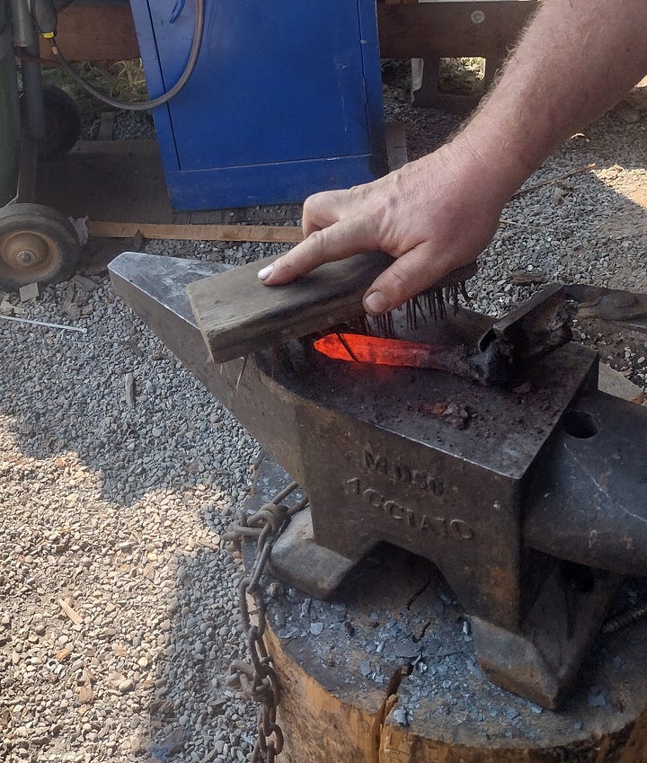 Heating the workpiece in the forge, then block-brushing the hot metal