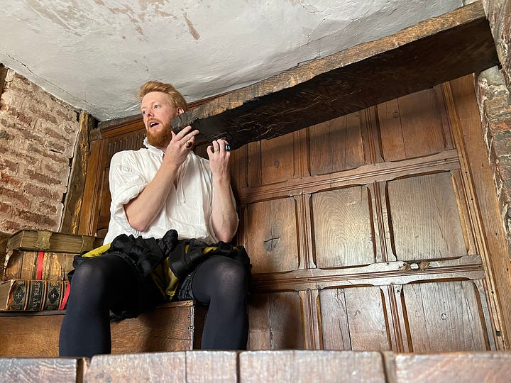House Manager Phil Downing shows the entrance to a Priest hide. Lesley Smith is Elizabeth I.