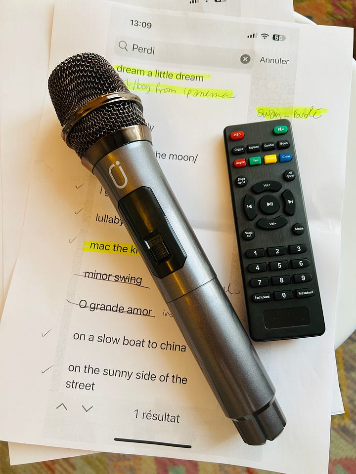 A home-style karaoke machine, microphone, remote control and a list of jazz standards