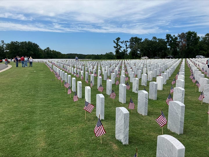 Veterans and local residents placing flags on gravesites at the Tallahassee National Cemetery