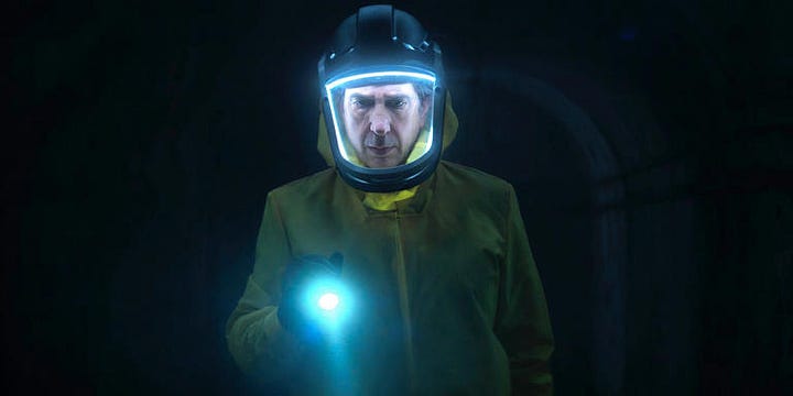 Two images of men in yellow hazmat suits with a blue light around their face.