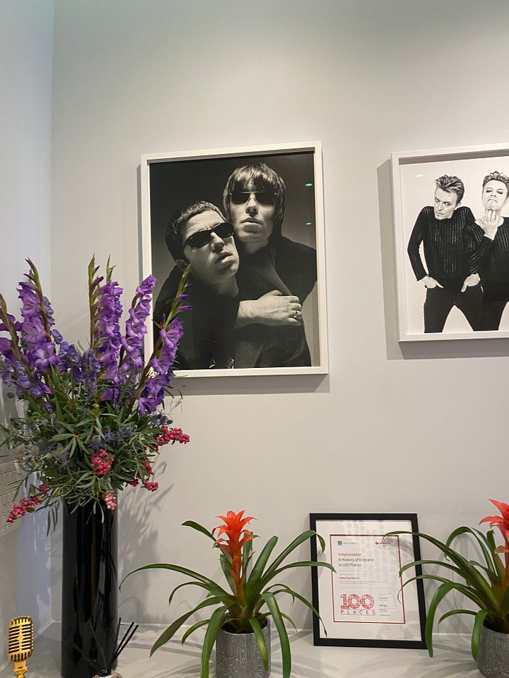 picture frames of Beatles album covers and photographs of Liam & Noel Gallagher and David Bowie.  