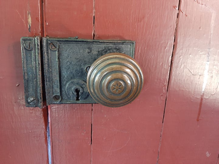A wooden chair sits next to a woodstove. An up close photo of a brass door knob.