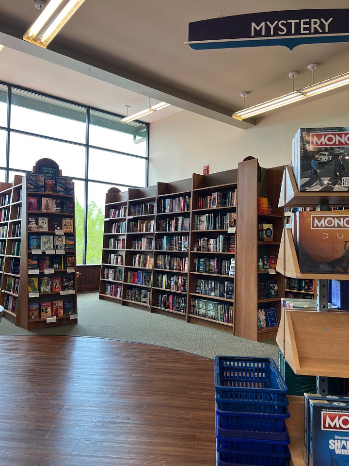 Top left: A wide shot of a large bookstore with a glass ceiling. Top right: A shot of a set of full bookshelves at the bookstore. Botton left: A wide shot of the bookstore showing the escalator down to the kids' section. Bottom right: A stack of books I purchased, which includes The Yellow Wall-Paper, An Ordinary Violence, The Dog of the North, I Love You So Much It's Killing Us Both, and Big Time.