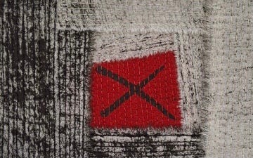 Black and grey quilts with red crosses, intricate and tactile pieces by Bethan Hughes at Ruthin Craft Centre