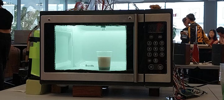 Images of a microwave modified to dispense drinks, one of which contains the author smiling beside the machine