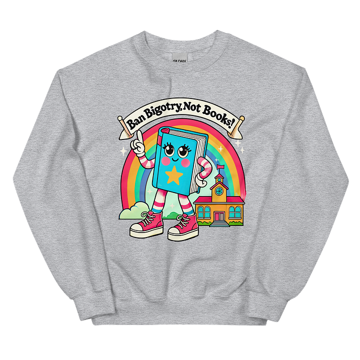 Two crewneck sweatshirts featuring a colorful design with a cartoon-style book character. The book has a smiling face, arms, and legs, wearing pink sneakers and waving a flag. Above the book, a banner reads "Ban Bigotry, Not Books!" in bold, playful font. The background features a rainbow and a small schoolhouse. One sweatshirt is pastel blue, while the other is light gray, both displaying the same vibrant illustration.