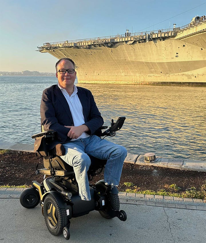 Well manicured Japanese garden, and John seated in his wheelchair next to the USS Midway aircraft carrier.