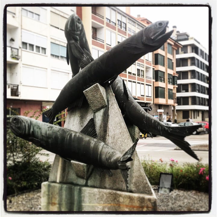 Three images of sculptures dedicated to the mighty anchovy in the port of Santoña, northern Spain.  