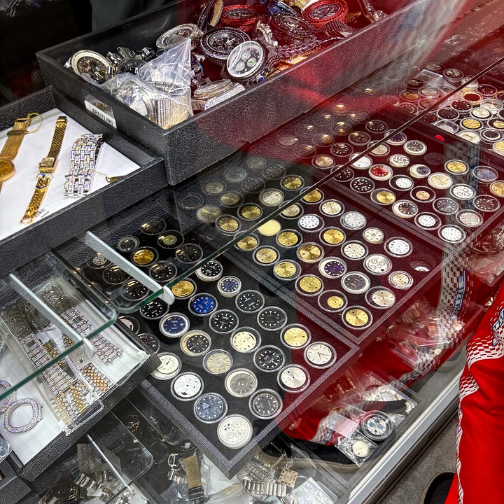 pile of vintage rolex watches, dials, and bracelets