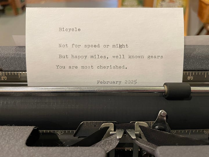 Typewriter set up on a card table in a bookshop and three index cards with haiku on them.