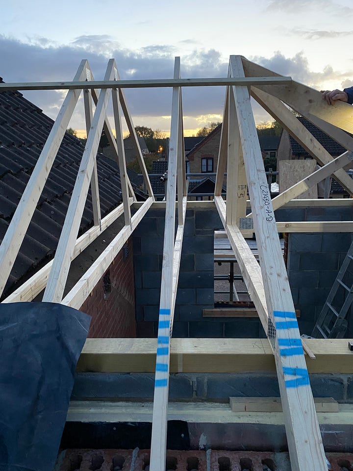 builders positioning the wooden roof trusses 