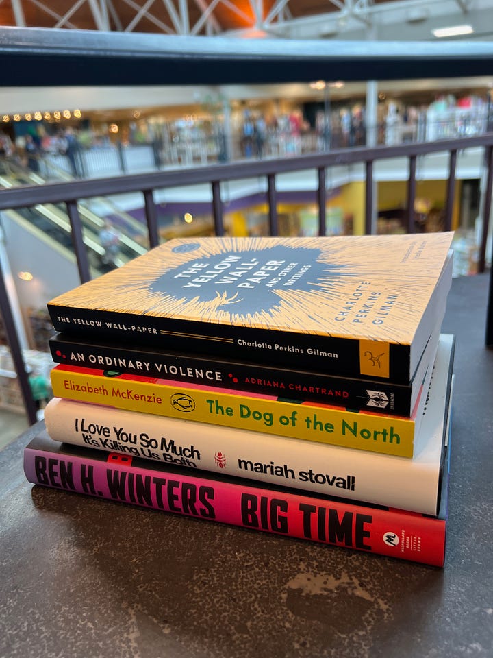 Top left: A wide shot of a large bookstore with a glass ceiling. Top right: A shot of a set of full bookshelves at the bookstore. Botton left: A wide shot of the bookstore showing the escalator down to the kids' section. Bottom right: A stack of books I purchased, which includes The Yellow Wall-Paper, An Ordinary Violence, The Dog of the North, I Love You So Much It's Killing Us Both, and Big Time.