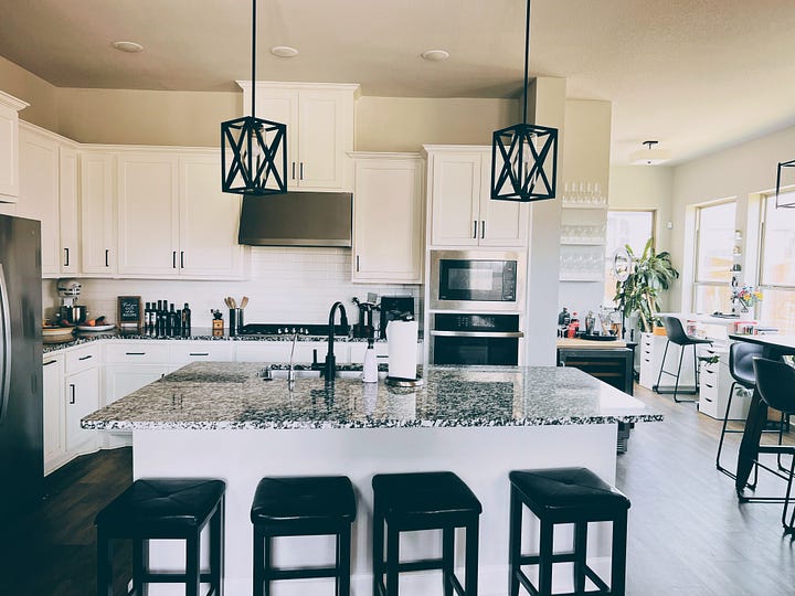 Open plan kitchen with centre Island and stools around it.