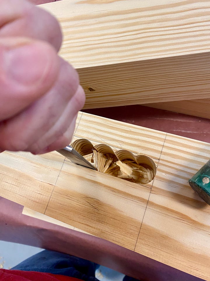 Chiseling a notch in a leg, gluing and clamping a leg, and then cutting a second notch with a chisel.