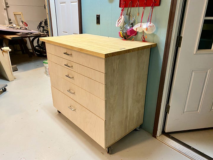 Heavy-duty caster wheels, laminated-pine top, walnut bow tie inlay, and full picture of a shop cabinet.