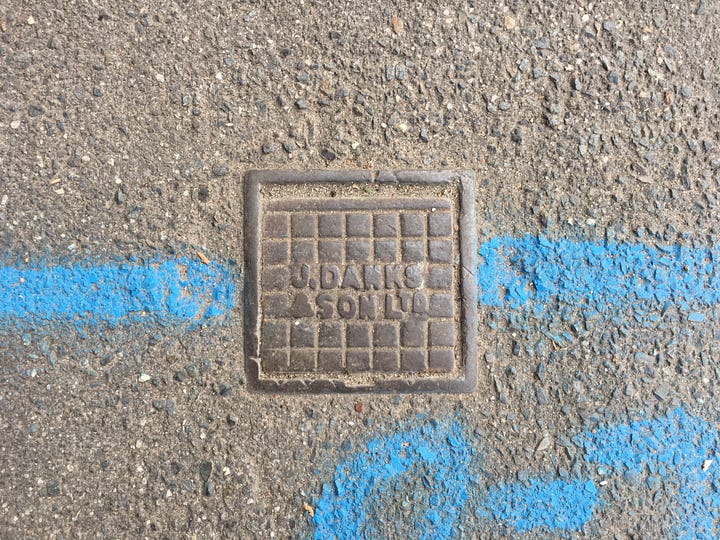 Sidewalk valve covers with the name John Danks & Son