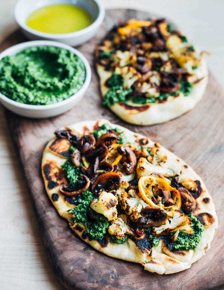 Flatbreads with cauliflower and pesto; a bowl of dip with roasted vegetables. 
