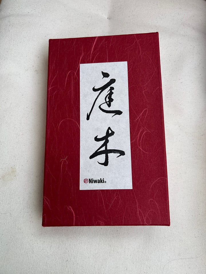 A red box with Japanese writing and a pair of metal scissors