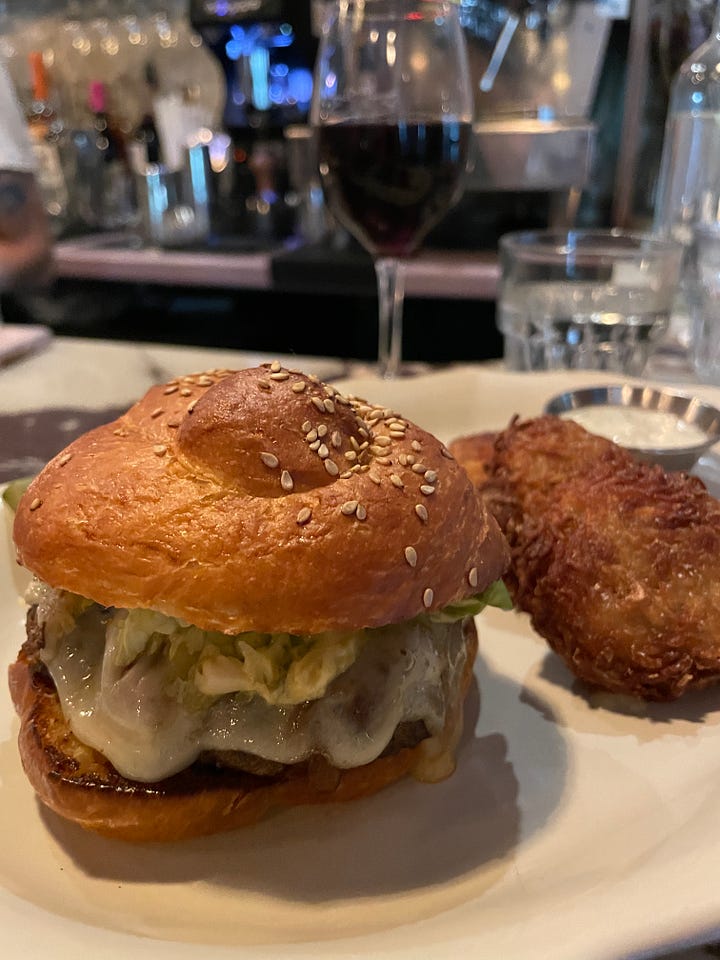 A cheese burger on a challah roll and a seven-layered chocolate cake