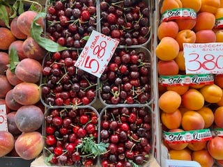 green peppers, red cherries, peaches, apricots, squash blossoms, strawberries at the market in Como, Italy