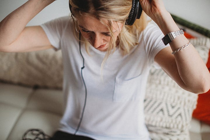 Alice holding a book, Alice putting on headphones to write.