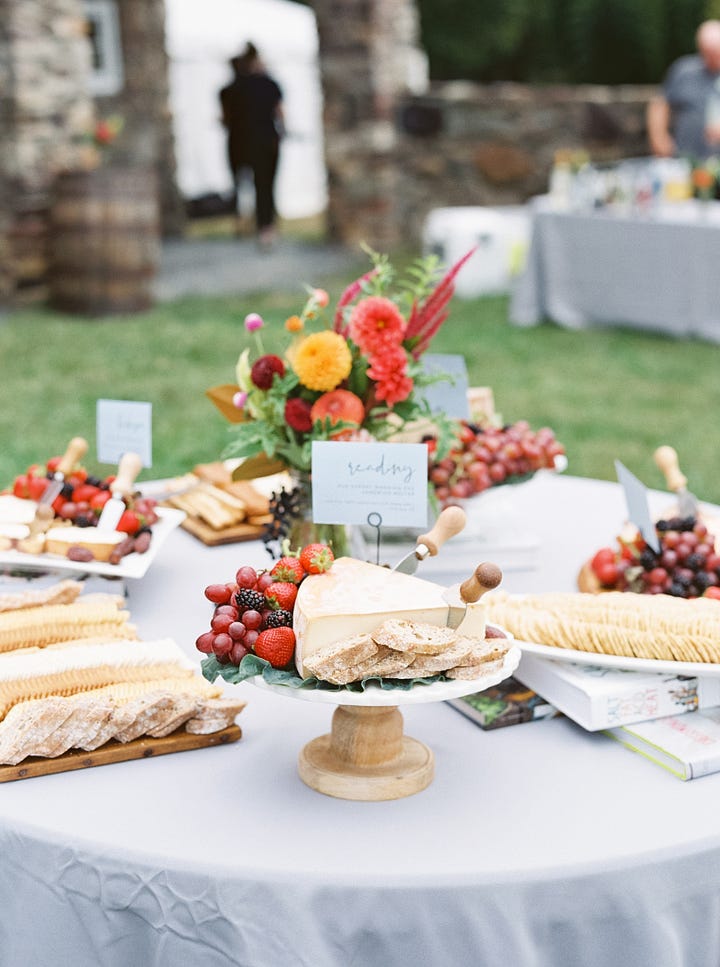 Image gallery of food at a wedding with lots of flowers in a barn.