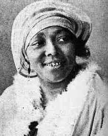 Two Black women blues singers from the 1920s, smiling and dressed in fancy evening wear