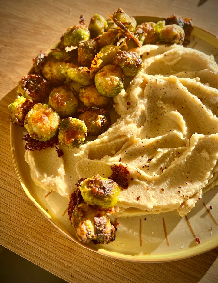 cheesy roast sprouts on a plate with celeriac dip