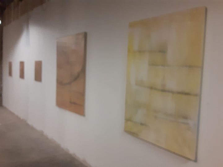 “Going Nowhere,” a collection of paintings by Newark-raised artist Kelly Ann Pinho, is be part of dual exhibitions of Pinho’s work, along with Sunil Garg’s, at Index Art Center’s temporary event space in Newark’s Teachers Village, 245 Halsey St. From left in a set of eight pictures we have, the Chilltown Blues pigeon looking at the set of paintings in which Pinho explores variations of a rusty or brown coloring. Second, are the green waves of 30x30 "Spring Heel Jack." Third is a picture of Pinho's green section, featuring a portion of them via two paintings, with the reflections of the two paintings in the windows to the left. There's also a slideshow with pictures of canopy and flowers - the text of which is referred to in the article below. The sixth photo has the Chilltown Blues pigeon in front of a sculpture peice by the dual art show's other artist, Sunil Garg. Garg's pieces evokes a jellyfish with lights coming from the floor as it, seven-feet high rotates in a greenhouse-like frame. The last pictre shows the transition of Pinho's rust-colored pieces to something more golden, evoking some of her own personal transitions of moving from "nowhere" to "somewhere."