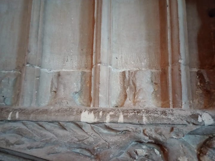 Bases of destroyed stone statuettes on wall above Hugh Despenser tomb