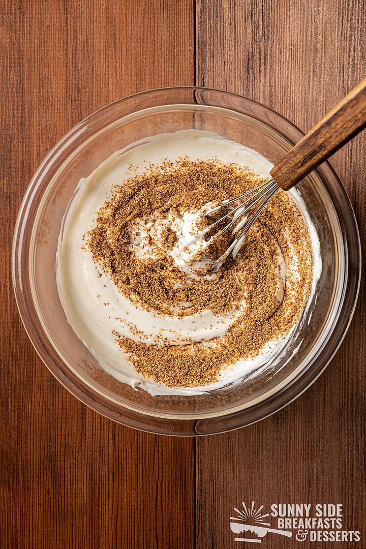 Mixing Greek yogurt in a glass bowl.