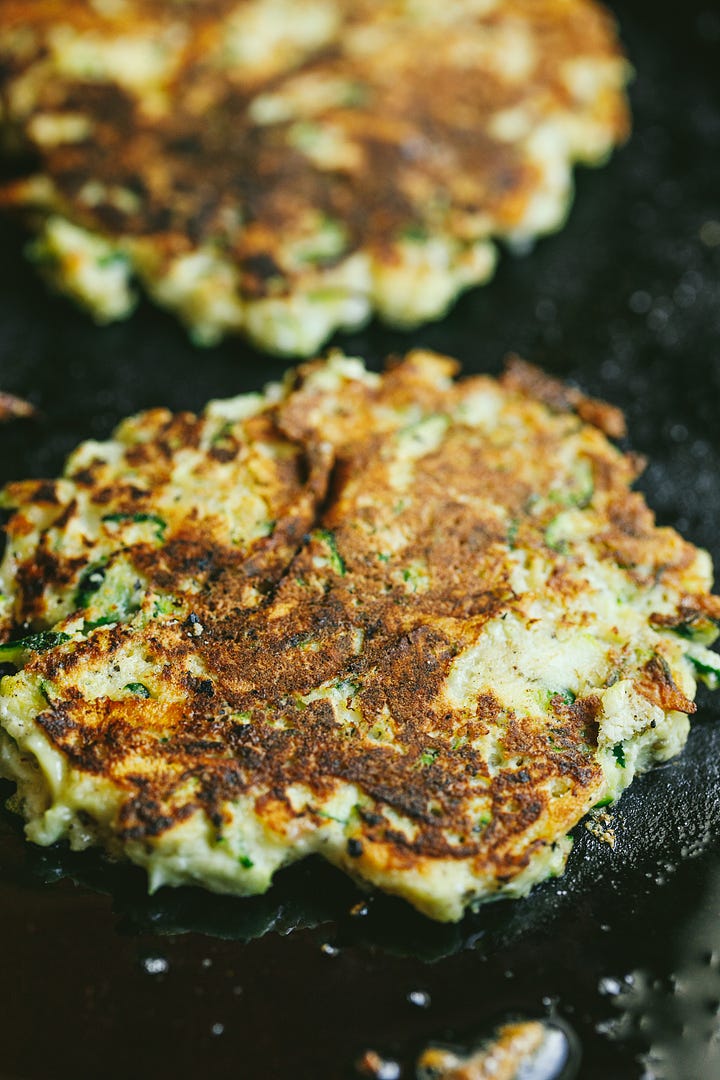 Shredded zucchini and frying the fritters.