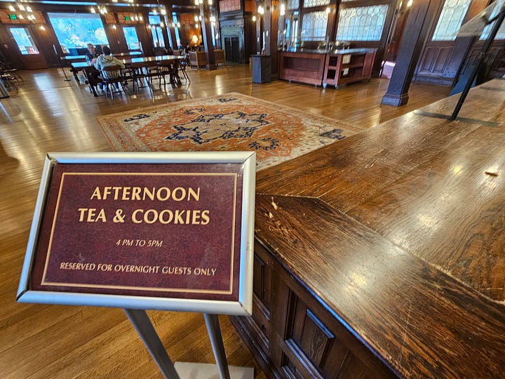 Images of the inside of Mohonk Mountain House, including a colorful Tiffany lamp, an ornate wooden fireplace with 2 portraits above, an antique clock, and a sign that says Afternoon Tea & Cookies.