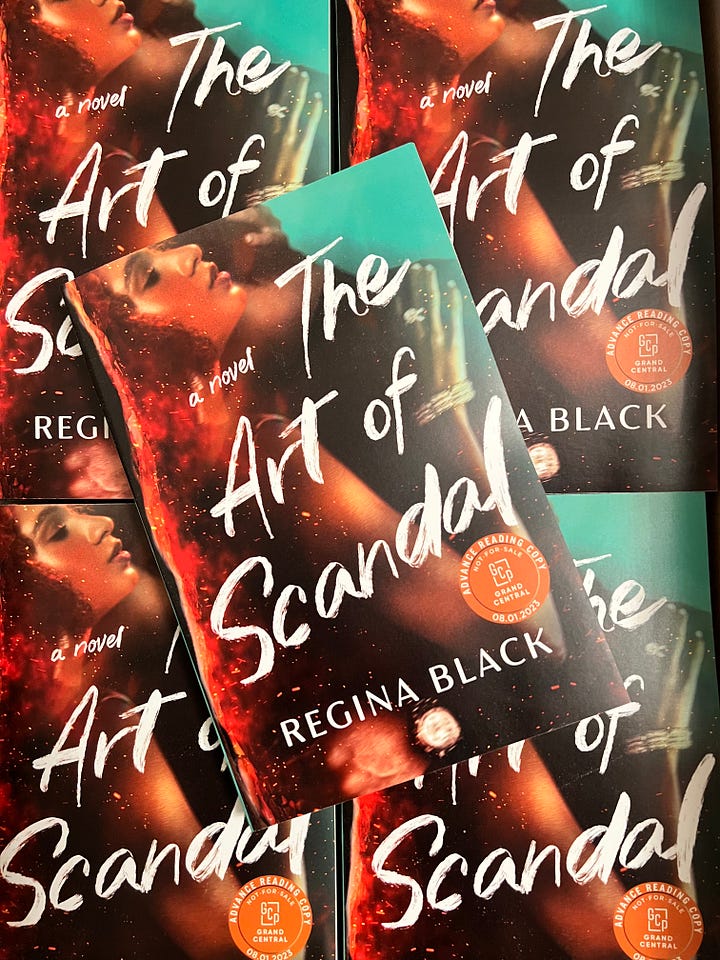 The photo on the right is a picture of THE ART OF SCANDAL galleys. The photo on the left is a picture of Regina Black holding three copies of the THE ART OF SCANDAL
