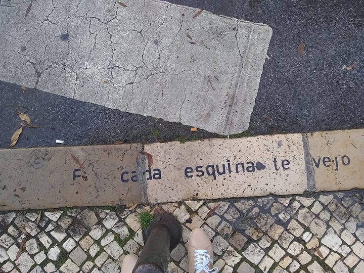 Calçada com texto escrito no chão: Em cada esquina te vejo, em cada esquina te vais