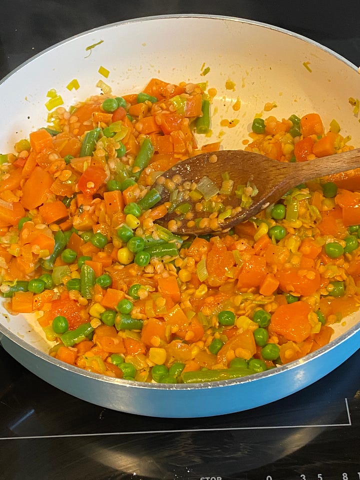 mixed vegetables frying in a large pan.