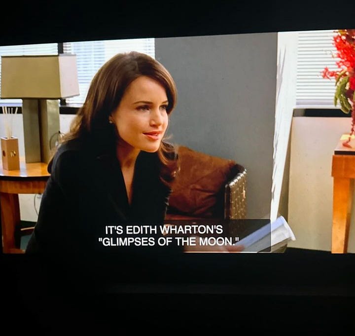 Screenshots from the television show “Entourage” showing actress Carla Gugino, a woman with long brown hair, seated in an office setting. Subtitles are visible at the bottom of the screen, displaying the text, “IT’S EDITH WHARTON’S ‘GLIMPSES OF THE MOON.’ STUDIO’S BEEN TRYING TO TACKLE IT FOR YEARS. NOBODY COULD GET A HANDLE ON IT. TAVI & SAM DID. THE SCRIPT IS WONDERFUL.”  