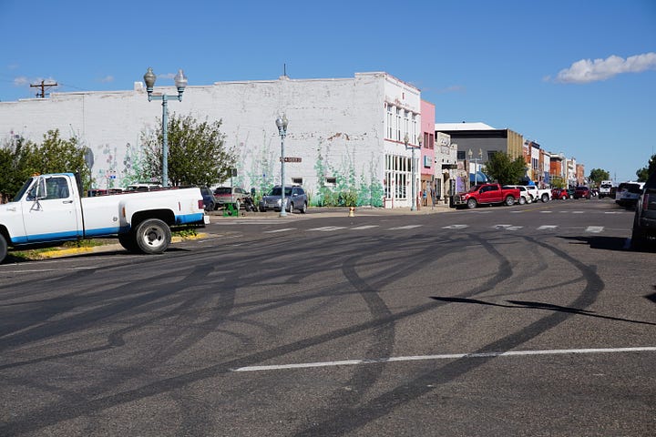 Black lines criss cross the road on a sidewalk and on the road itself.