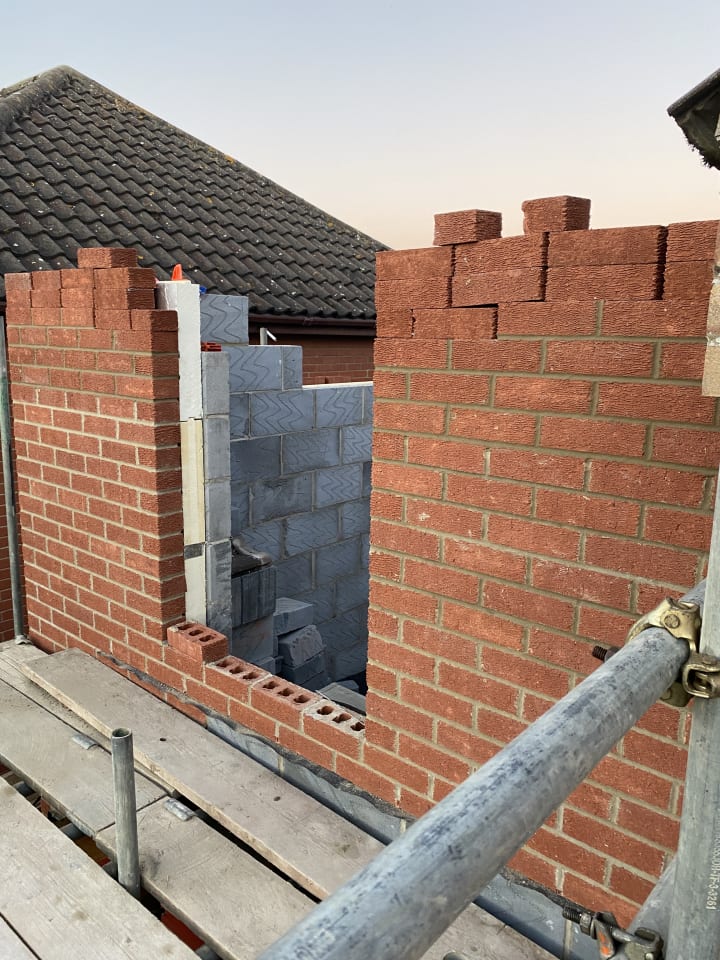 red bricked wall with window opening