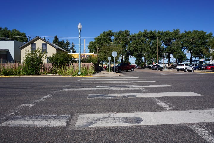 Black lines criss cross the road on a sidewalk and on the road itself.
