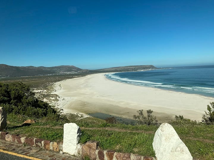 View of white sand, clear water and mountains