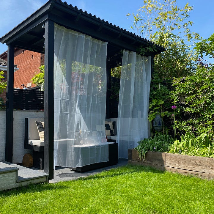 pergola with voiles attached giving off the Ibiza vibes