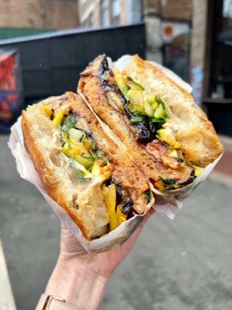 Dusty Knuckle sandwiches and menu with the sandwich ingredients including aubergine Muhammara, green tahini, pickled red onion, dill and mint