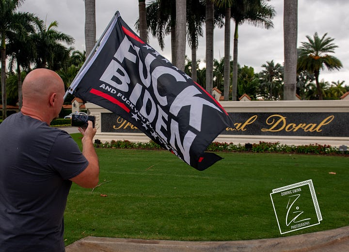 Trump supporters wave flags while standing in front of the sign at Trump National Doral. 