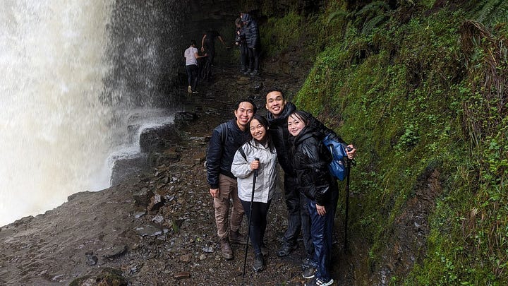 people smiling at the waterfalls of the brecon beacons