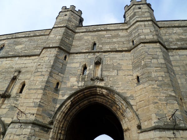 t.l: Exchequer Gate between the castle and the cathedral; T.R.: the Lucy Tower in the castle; L.L: ruins of the Medieval Bishop's Palace; L.R. Lincoln Cathedral