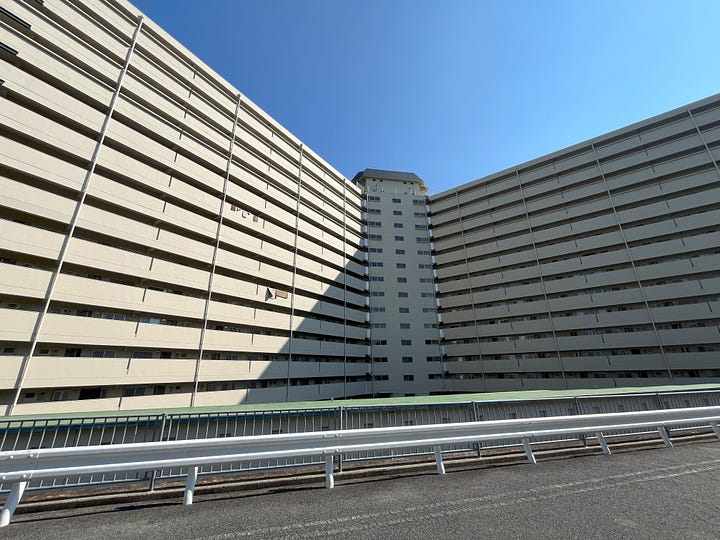 Two pictures of public housing blocks on the outskirts of Kobe. They look like huge walls.