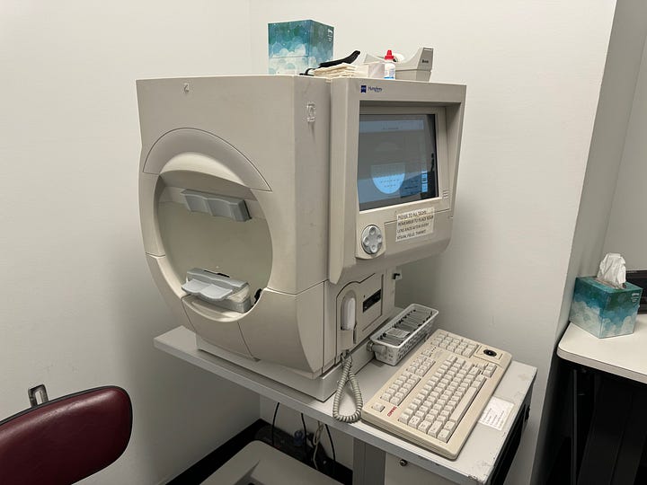 (Image 1) A photo of a beige computer-machine with a keyboard in front of it. (Image 2) ArmaniXR sits with his chin rested on a large, beige machine. He looks through it as soft light glows on his face.