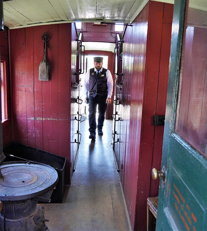 Interior of a historic caboose with stove and red paneling.